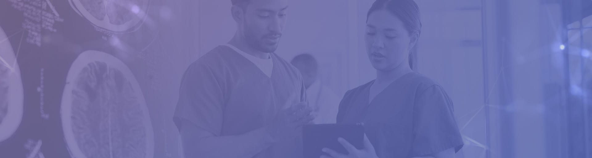 Two medical staff discuss over a tablet.